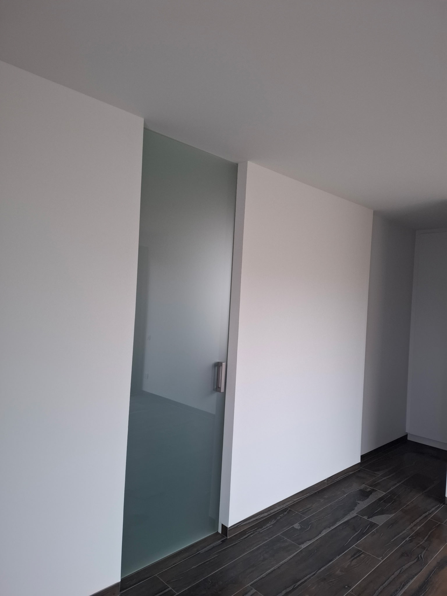 Orange-handled paint roller in a tray filled with gray paint, perfect for DIY projects.